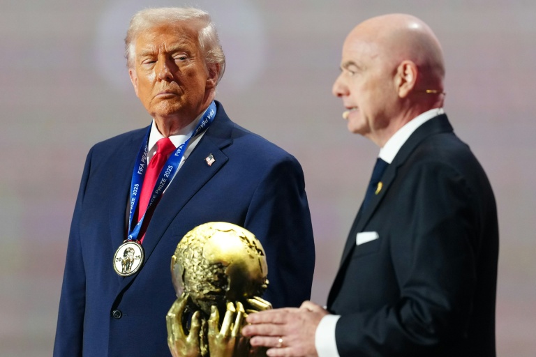 Donald Trump (g) reçoit des mains de Gianni Infantino le Prix de la paix Fifa, le 5 décembre 2025 à Washington