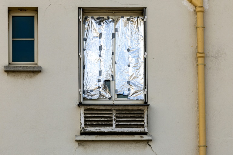 Une fenêtre recouverte d'une couverture de survie à Paris le 20 juillet 2026