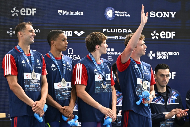 Léon Marchand et l'équipe française sur le podium après le relais 4x200 m aux Championnats d'Europe de natation.