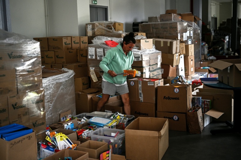 Une volontaire au milieu des fournitures scolaires collectées en faveur des sinistrés du mégafeu de Gironde, le 28 août 2026 au Porge