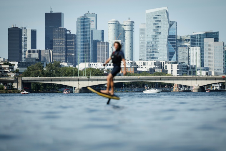 Le moniteur d'e-foil et cofondateur du club Foil in Paris Nicolas Pernodet sur son surf électrique sur la Seine, devant le quartier d'affaires de La Défense, à Paris, le 2 août 2026