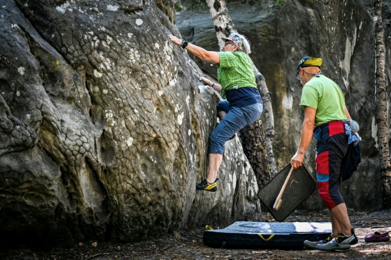 Un homme escalade un rocher à Fontainebleau lors de la réouverture au public
