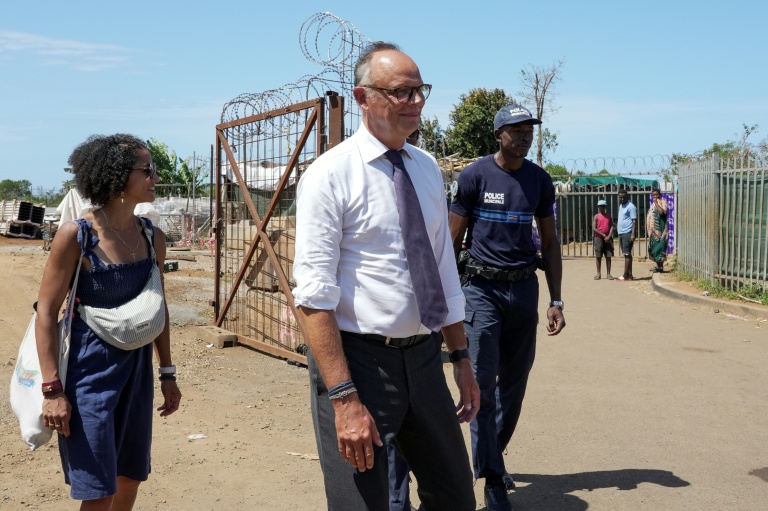 Édouard Philippe (c), fondateur et président du parti Horizons, maire du Havre et candidat à l'élection présidentielle, visite un camp de réfugiés dans le village de Tsoundzou 2, à Mamoudzou, le 21 août 2026 sur l'île de Mayottte