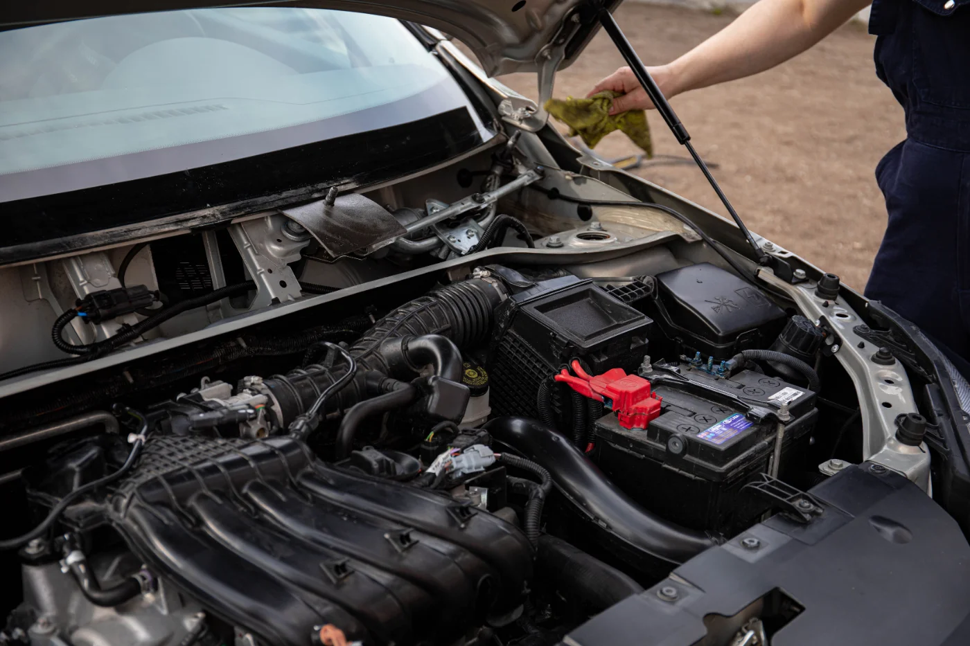 Prix changement alternateur : mécanicien inspectant le compartiment moteur et la batterie