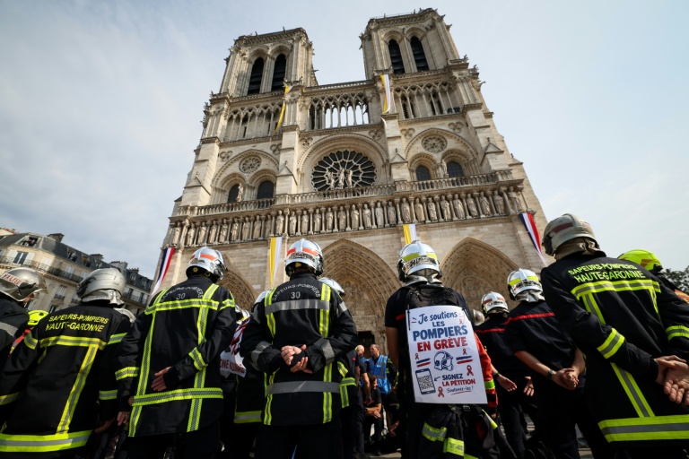 Des sapeurs-pompiers observent une minute de silence devant la cathédrale Notre-Dame de Paris, lors d'une manifestation, le 28 septembre 2026