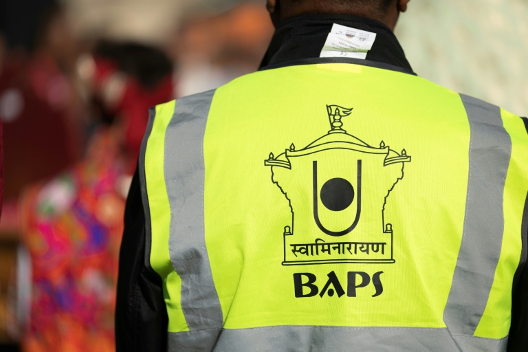 Un participant à la célébration du premier temple BAPS en France porte un gilet jaune au logo de la communauté, le 3 septembre 2026, à Paris