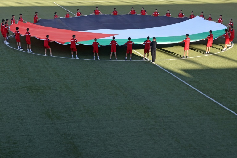 Un drapeau palestinien déployé sur le terrain avant le coup d'envoi du match de reprise après la guerre, le 4 septembre 2026 à Al-Ram en Cisjordanie