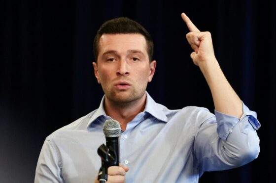 Jordan Bardella s'exprime lors d'une conférence, affirmant la fermeté du RN envers la Russie.