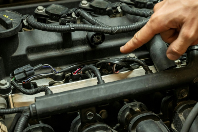 Le câblage reliant un boîtier de conversion au bioéthanol aux injecteurs de carburant d'un moteur, dans un garage à Marseille, le 18 septembre 2026