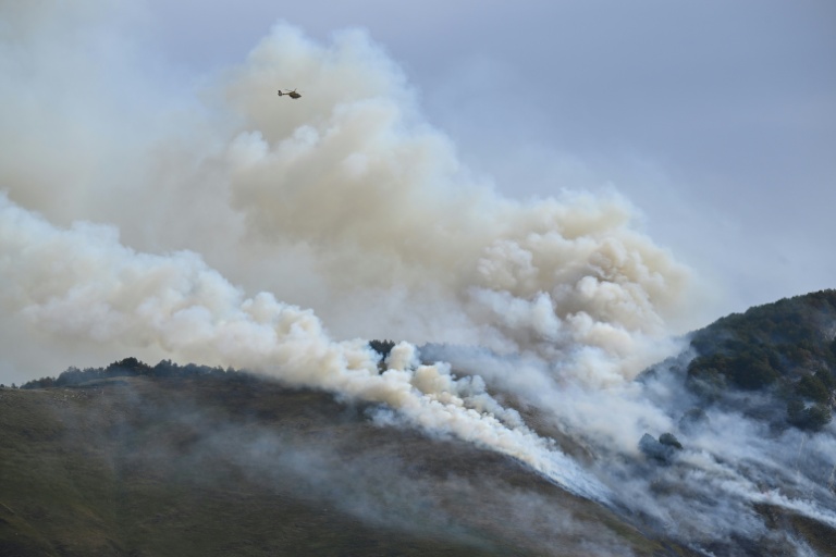 Un hélicoptère de la Sécurité civile survole des montagnes lors d'un incendie de forêt près d'Etsaut, le 6 septembre 2026 dans les Pyrénées-Atlantiques