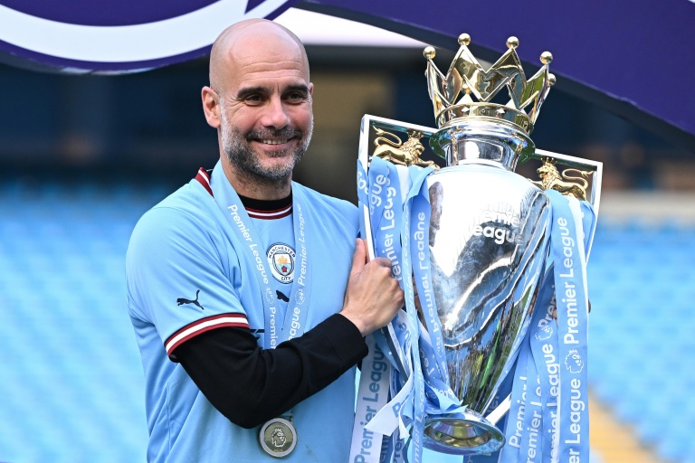 Pep Guardiola et le trophée de champion d'Angleterre remporté par son club de Manchester City, le 21 mai 2023