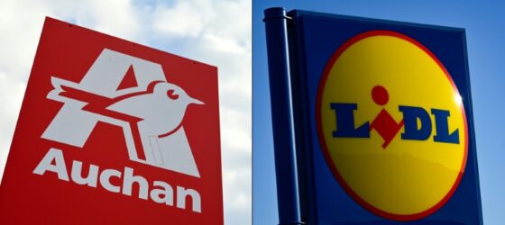 Logos des enseignes Auchan et Lidl sur des panneaux publicitaires.