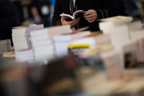 Client feuilletant un livre dans une librairie indépendante à Paris