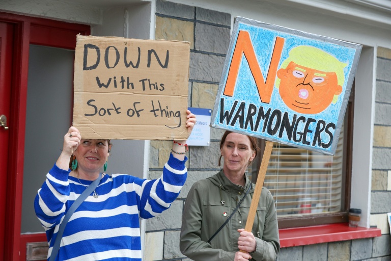 Des personnes brandissent des pancartes lors d’une manifestation contre la visite du président américain Donald Trump, à Doonbeg, dans l’ouest de l’Irlande, le 12 septembre 2026
