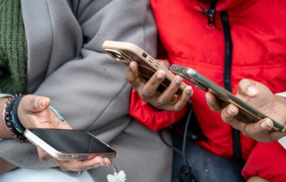 Des jeunes utilisant leurs téléphones mobiles, symbolisant l'interdiction des réseaux sociaux pour les moins de 15 ans.