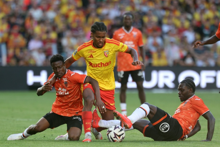 Le défenseur de Lens Kyllian Antonio (C) pris en tenaile pat les Lorientais Arsène Kouassi (d) et Nathaniel Adjei en Ligue 1 le 5 septembre 2026 à Lens