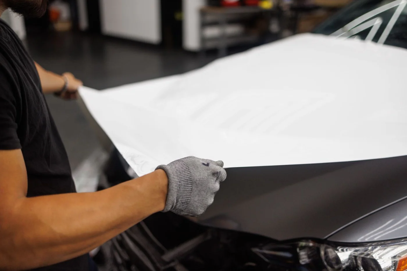 Pose d'un film vinyle de covering sur la carrosserie d'une voiture