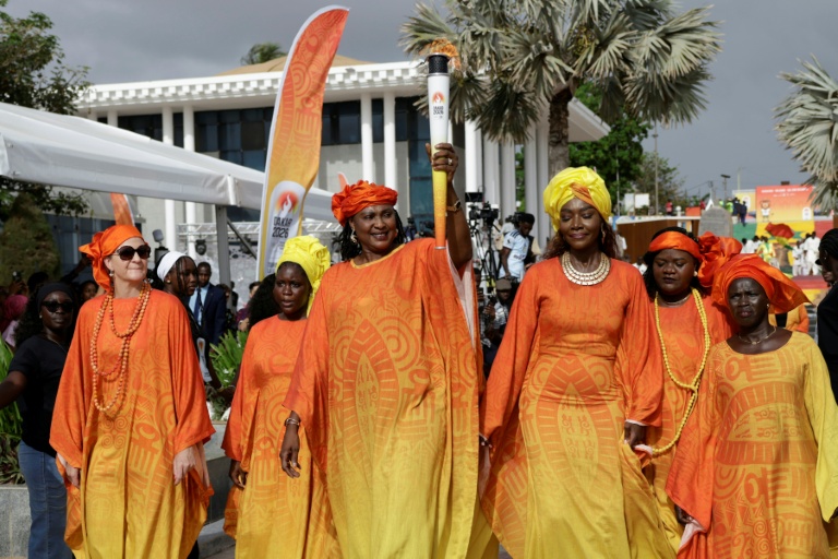 Mame Maty Mbengue, ancienne basketteuse sénégalaise, brandit la flamme des Jeux Olympiques de la Jeunesse à Dakar le 12 septembre 2026.