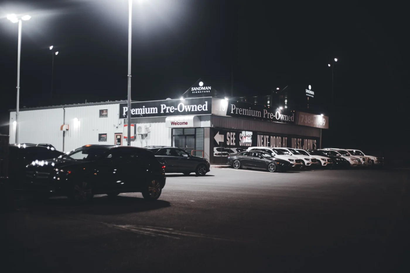 Voitures d'occasion alignées devant une concession automobile