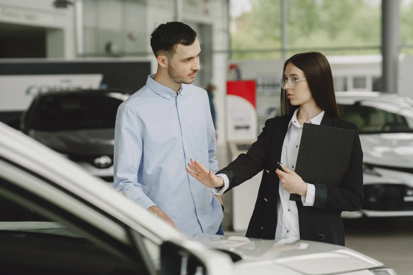 Discussion entre un vendeur et une cliente dans une concession