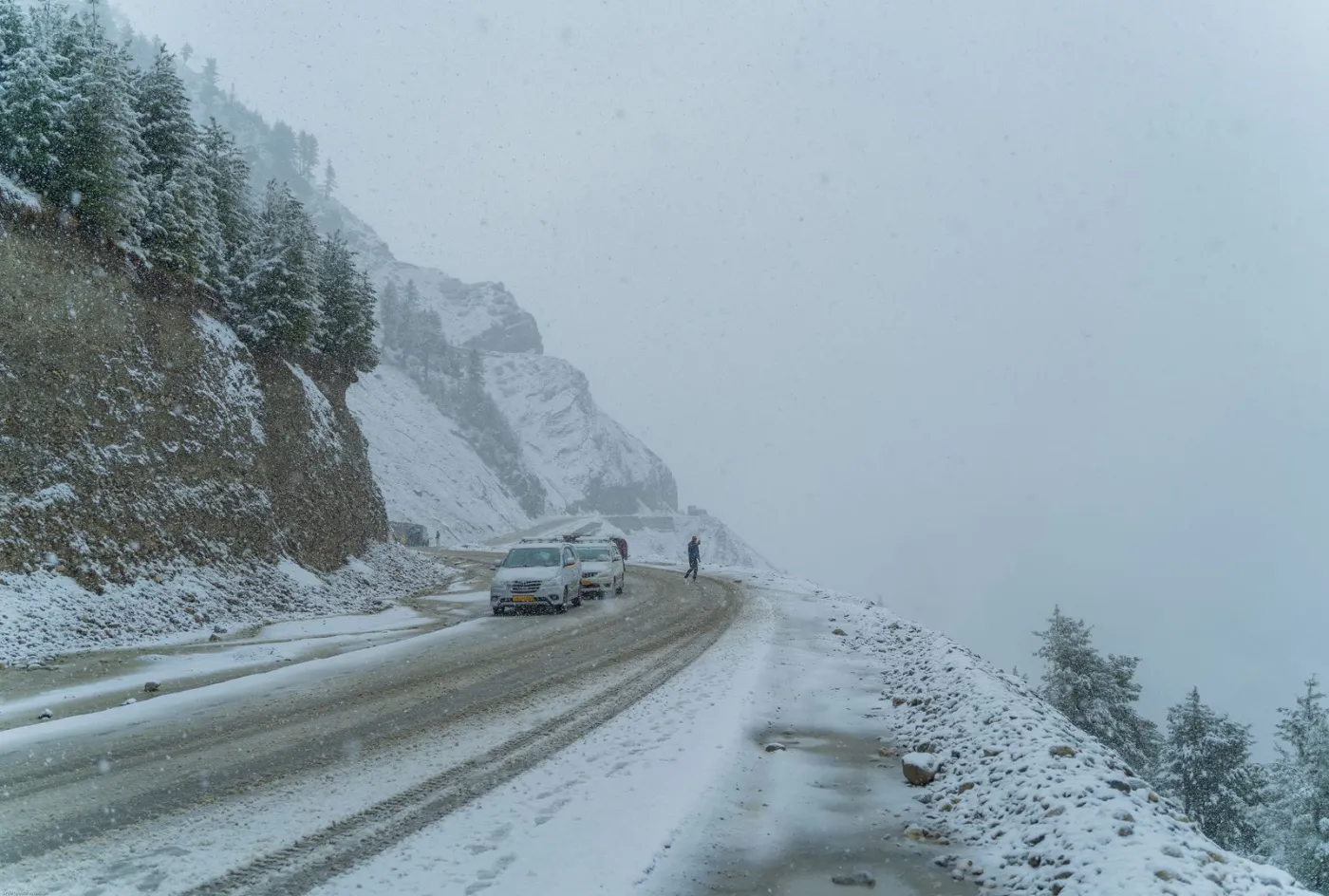 Voiture sur une route de montagne enneigée en hiver