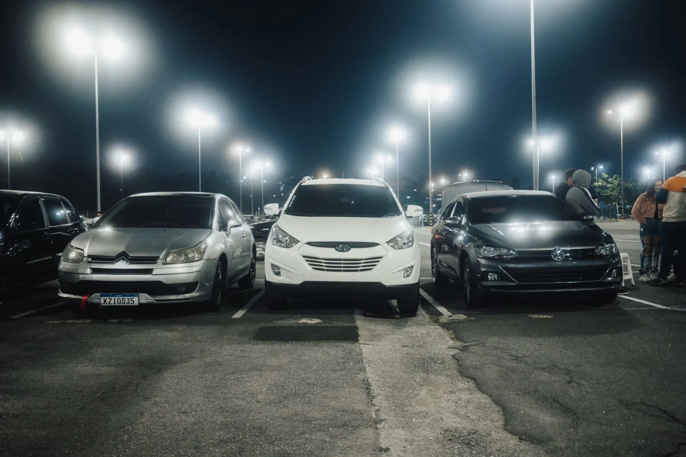 Voitures stationnées sur un parking éclairé en ville