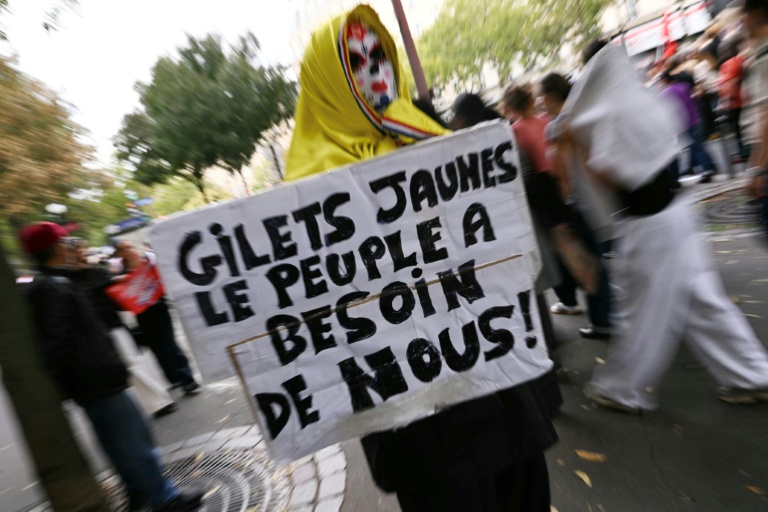 Un manifestant tient une pancarte en appelant aux gilets jaunes, le 13 octobre 2026 à Paris