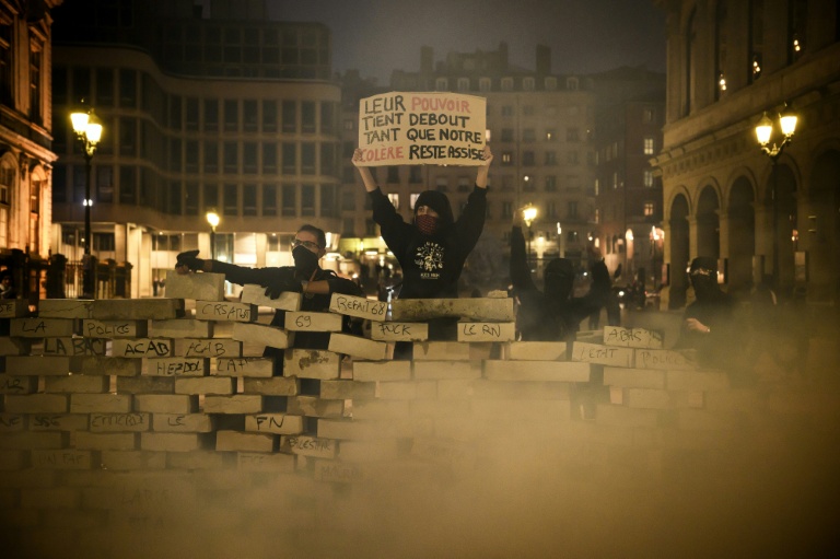 Des protestataires derrière une barricade érigée avec des pavés lors d'une manifestation contre la vie chère à Lyon, le 17 octobre 2026