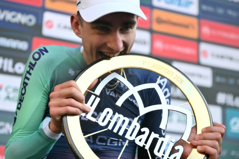 Paul Seixas, vainqueur du Tour de Lombardie, célèbre avec son trophée.