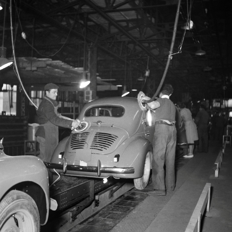 Des ouvriers polissent la carrosserie d'une 4CV sur la chaîne de montage de l'usine Renault, en avril 1950 sur l'île Seguin, à Boulogne-Billancourt, dans les Hauts-de-Seine