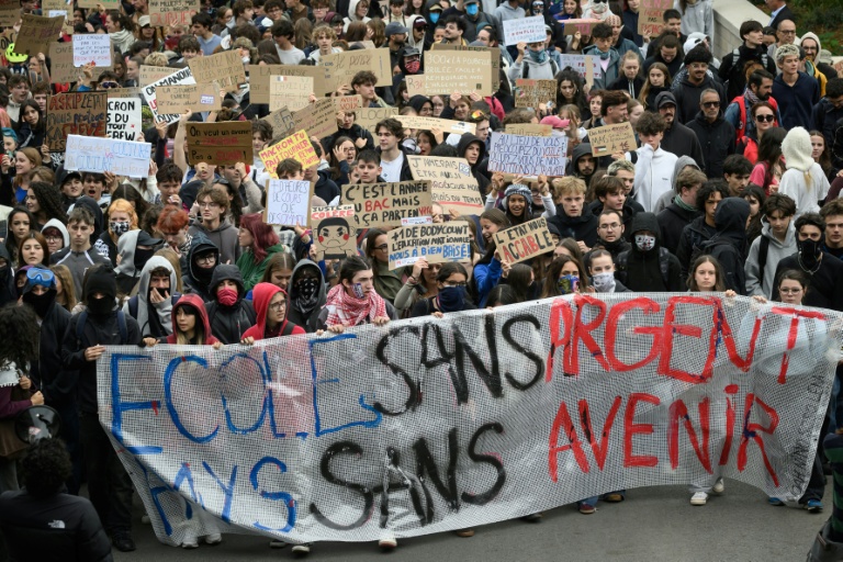 Des étudiants défilent derrière une banderole sur laquelle est inscrit 
