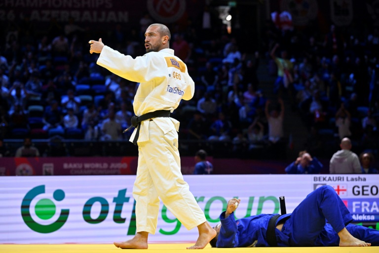 Le Géorgien Lasha Bekauri (debout à gauche) bien que blessé au genou a remporté son combat contre le Français Aleksa Mitrovic lors du repêchage par équipe mixte aux Mondiaux de judo de Bakou le 11 octobre 2026 en Azerbaïdjan
