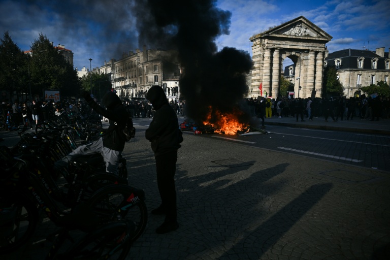 Un protestataire donne un coup de pied dans un vélo près d’un feu, lors d’une manifestation contre la vie chère à Bordeaux, le 17 octobre 2026