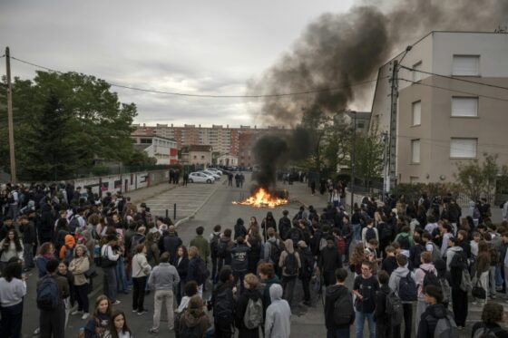Manifestation lycéenne en France avec des élèves rassemblés autour d'un feu.