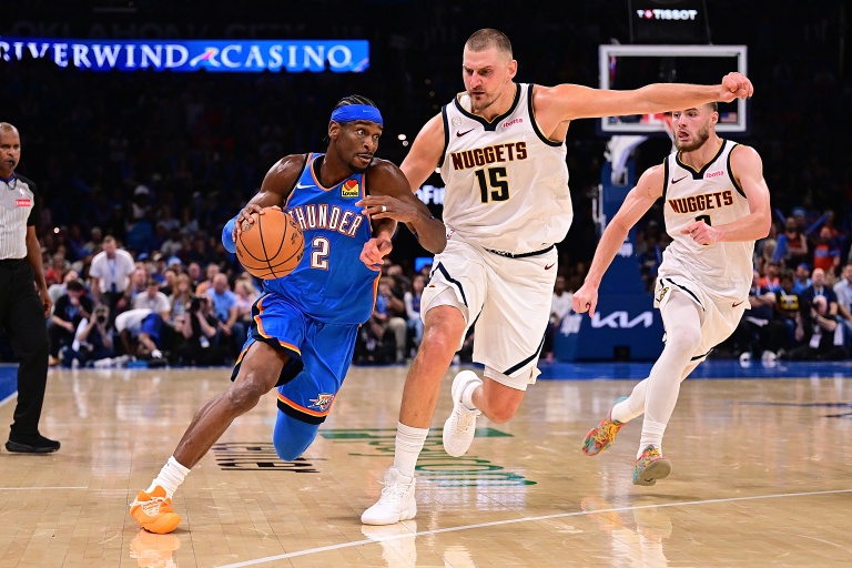 Shai Gilgeous-Alexander (g) tente de déborder Nikola Jokic  lors du match NBA du Thunder contre les Denver Nuggets, le 22 octobre 2026 à Oklahoma City