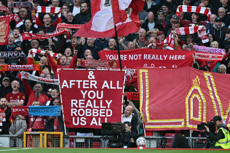 Des banderoles des supporters de Liverpool se moquant du scandale financier visant leurs rivaux de Manchester City, lors du match de Premier League opposant les deux équipes, le 11 octobre 2026