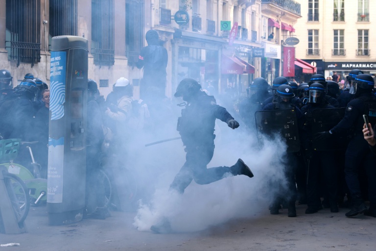 Un policier donne un coup de pied dans une grenade lacrymogène lors d'une manifestation de lycéens place de la Bastille à Paris, le 8 octobre 2026