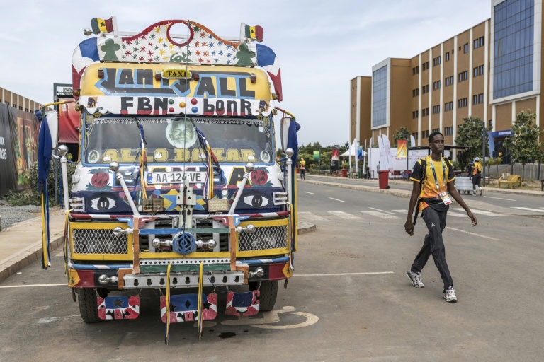 Un volontaire passe devant un bus appelé 