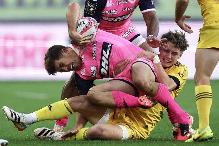 Le joueur du Stade français Louis Carbonel, en rose, plaqué par celui de la Rochelle Diego Jurd, lors d'un match de Top 14 entre les deux équipes, le 31 octobre 2026 à Paris