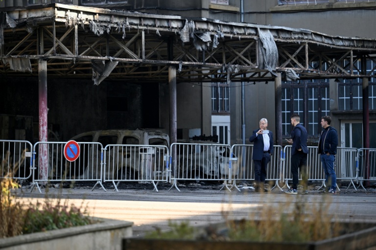 Le maire de Metz, Francois Grosdidier (G) près de véhicules incendiés sous le préau du collège François Rabelais à Metz, le 3 octobre 2026