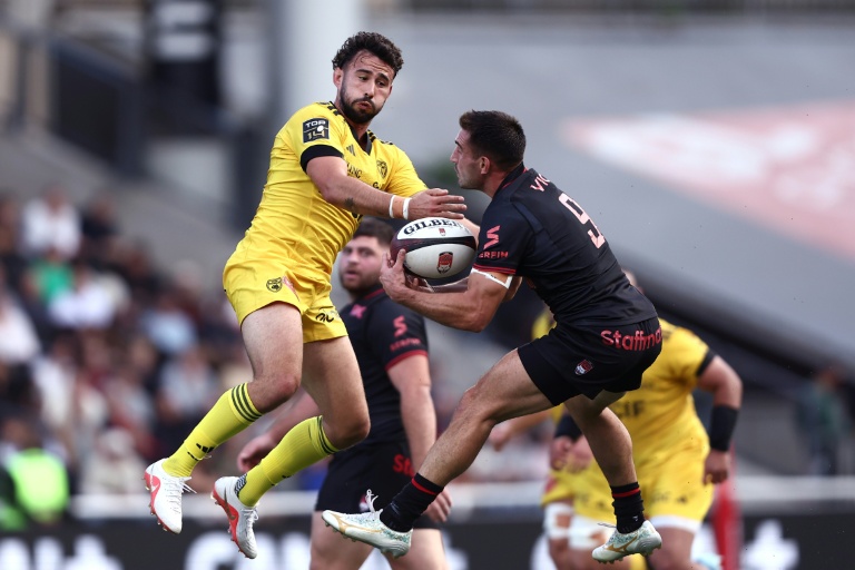 Le demi d'ouverture de La Rochelle Antoine Hastoy (à g.) et le demi de mêlée de Lyon Baptiste Couilloud à la lutte lors du match de top-14 samedi au stade Gerland Stadium de Lyon.