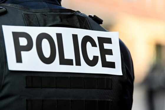 Un agent de police avec un gilet portant l'inscription POLICE.