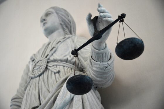 Statue de la justice tenant une balance, symbolisant le procès sur les vols de monnaies anciennes.