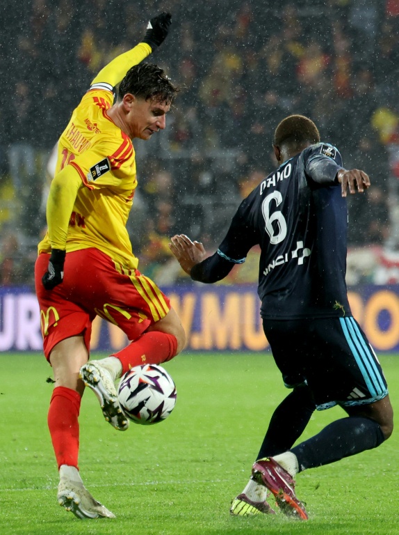 L'attaqua,nt du RC Lens Florian Thauvin contrôle le ballon devant Otavio, le défenseur du Paris FC, en Ligue 1 le 24 octobre 2026 au stade Bollaert à Lens