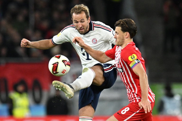 Harry Kane et un défenseur en pleine action lors d'un match de football.