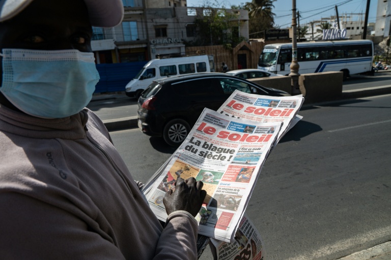 Un vendeur de journaux tient la Une du journal 