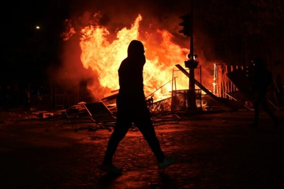Un manifestant devant un incendie lors des violences en France contre la vie chère.