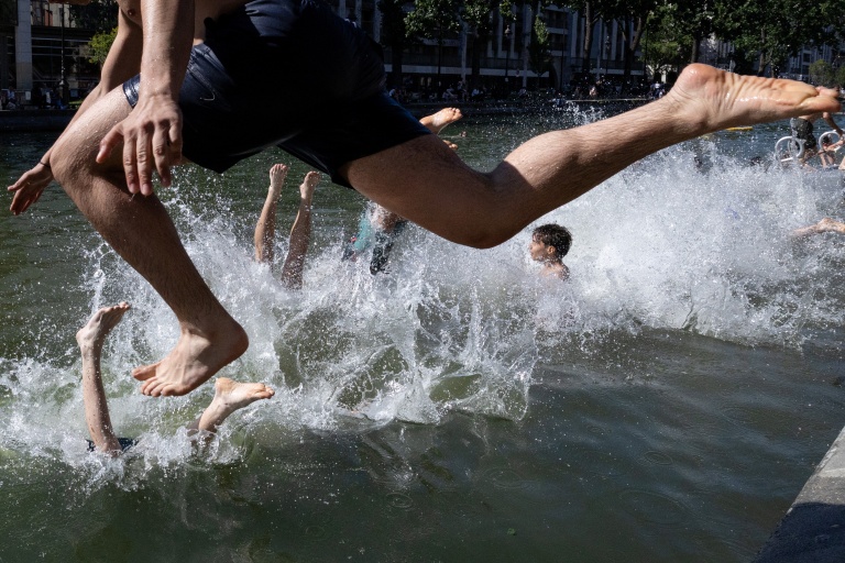 Des jeunes sautent dans le Bassin des Recollets sur le canal Saint-Martin, le 17 juin 2026 à Paris