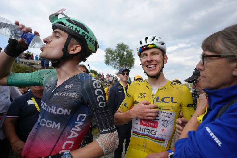 Le coureur slovène de l'équipe UAE, Tadej Pogacar (d.), vêtu du maillot jaune de leader du classement général, célèbre sa victoire dans la 14e étape du Tour de France 2026, aux côtés du coureur français Paul Seixas (g.), de l'équipe Decathlon CMA CGM, au Markstein (Vosges), le 18 juillet 2026
