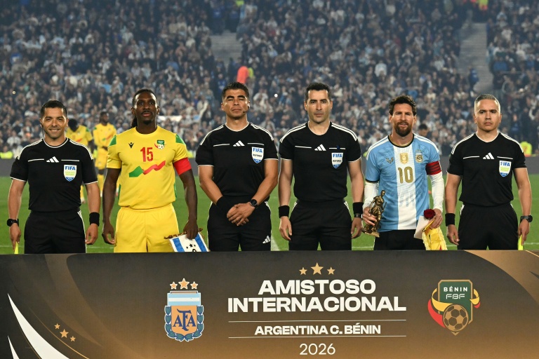 L'arbitre chilien Fernando Vejar (au centre à droite) pose avec l'attaquant argentin Lionel Messi et le milieu du Bénin Sessi D'Almeida avant le match amical enntre les deux pays, le 6 octobre 2026 à Buenos Aires